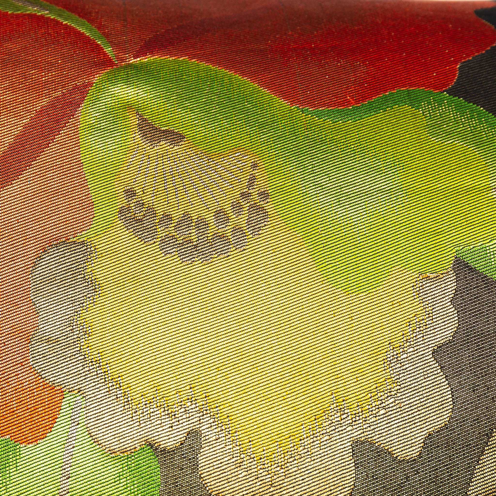 Close up of yellow and gold flower motif on a black and red silk Japanese obi pillow.